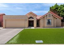 Charming single-story home with lush green lawn, desert landscaping, and a red tile roof at 11131 E Becker Ln, Scottsdale, AZ 85259