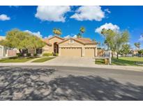 Charming single-story home with a three-car garage, lush landscaping, and a beautiful blue sky backdrop at 1241 W Lobster Trap Dr, Gilbert, AZ 85233