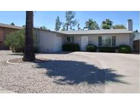 Charming single-story home featuring a low-maintenance gravel yard and mature landscaping at 135 E Ellis Dr, Tempe, AZ 85282