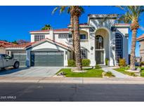 Stunning two-story home featuring an arched entryway, three-car garage, and lush landscaping, all under a clear blue sky at 1442 W Laurel Ave, Gilbert, AZ 85233