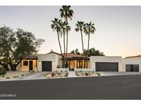 Stunning exterior elevation features palm trees, a red tile roof, and multiple dark-stained garage doors at 23002 N Country Club Trl, Scottsdale, AZ 85255