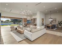 Bright open-concept living space features a modern chandelier, light wood floors, and seamless indoor-outdoor living at 23002 N Country Club Trl, Scottsdale, AZ 85255