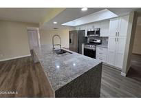 Bright kitchen with granite counters, stainless appliances, and a skylight for natural light at 3849 W Mauna Loa Ln, Phoenix, AZ 85053