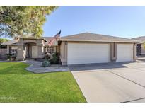 Charming single-story home with a three-car garage, well-maintained lawn, and an American flag at 4407 W Avenida Del Sol --, Glendale, AZ 85310