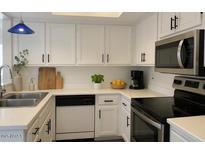 Bright kitchen features white cabinetry, stainless steel appliances, and ample counter space at 461 W Holmes Ave # 271, Mesa, AZ 85210