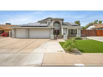 Charming home featuring a spacious three-car garage, solar panels, and low maintenance front yard at 5020 E Dallas St, Mesa, AZ 85205