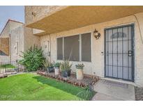Inviting front entrance with secured door, decorative plants, and artificial grass at 6304 N 47Th Ave, Glendale, AZ 85301