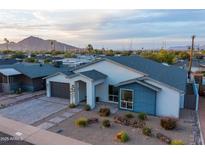 Contemporary home featuring a well-manicured desert landscape and mountain views at 6450 E Vernon Ave, Scottsdale, AZ 85257