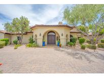 Stunning home entrance with arched doorway, double doors, desert landscaping, and brick paver driveway at 700 N Dobson Rd # 34, Chandler, AZ 85224