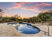 Inviting pool featuring beautiful stone surround and waterfall feature surrounded by desert landscaping at 7304 E Bent Tree Dr, Scottsdale, AZ 85266