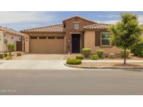 Charming home showcasing a blend of neutral stucco and stonework, complemented by a tile roof and landscaped front yard at 9757 E Red Giant Dr, Mesa, AZ 85212