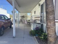 A covered patio with furniture and a car parked nearby is inviting for outdoor relaxation at 1004 S Kiowa Cir, Apache Junction, AZ 85119