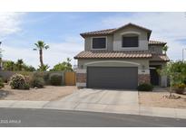 Charming two-story home featuring desert landscaping, a two car garage and a neutral color palette at 13486 W Evans Dr, Surprise, AZ 85379