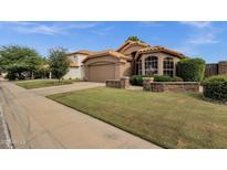 Charming home with a well-manicured lawn, attractive landscaping, and a stylish terracotta-tiled roof at 1558 W Maplewood St, Chandler, AZ 85286