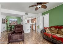 Inviting living room featuring stylish furniture, wood floors, and a peek into the dining area and kitchen at 16602 N 25Th St # 204, Phoenix, AZ 85032