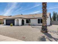 Attractive residence featuring an arched entryway, manicured desert landscaping, and a stylish exterior at 3011 E John Cabot Dr, Phoenix, AZ 85032
