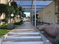 Scenic covered walkway with stone details and manicured landscaping leading to property amenities at 4411 N 40Th N St # 37, Phoenix, AZ 85018