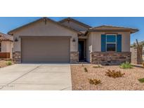 Charming home featuring a gray stucco exterior, blue shutters, desert landscaping and a large two car garage at 7229 E Cattle Call St, San Tan Valley, AZ 85143