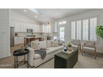 Bright and airy living room with skylight, white walls, comfortable seating, and open concept kitchen access at 7297 E Black Rock Rd, Scottsdale, AZ 85255