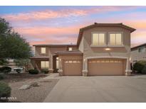 Two-story home featuring a three car garage and a well-maintained desert landscape at 7546 W Mary Jane Ln, Peoria, AZ 85382