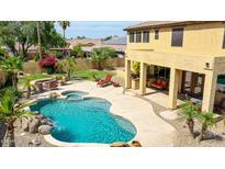 Stunning backyard oasis with pool, spa, covered patio, and lush landscaping perfect for relaxing and entertaining at 11150 S Star Ct, Goodyear, AZ 85338