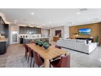 Open-concept living and dining area featuring modern finishes, a sleek kitchen, and comfortable seating at 14837 W Honeysuckle Dr, Surprise, AZ 85387