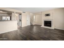 Spacious living room with dark wood floors, a fireplace, and stainless steel appliances at 1645 W Baseline Rd # 2098, Mesa, AZ 85202