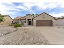 Charming single-story home featuring a well-manicured desert landscape and two-car garage, in a sunny neighborhood at 16514 W Sandia Park Dr, Surprise, AZ 85374