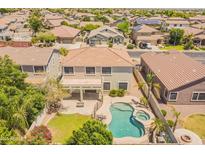 Aerial view of backyard with pool, spa, covered patio, grass and other homes in a well-maintained neighborhood at 2102 S Sabrina --, Mesa, AZ 85209