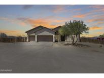 Inviting desert home featuring a stone facade, three-car garage, and mature landscaping against a scenic sunset backdrop at 30511 N 162Nd Way, Scottsdale, AZ 85262