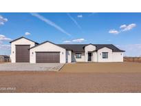 Stylish exterior showcases a modern, white-colored home with a spacious driveway and ample garage space at 34449 N Elk Run Rd, San Tan Valley, AZ 85143