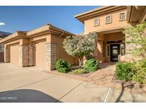 Beautiful home exterior with a well-manicured front yard, desert landscaping, and a three-car garage at 42023 N Bridlewood Way, Anthem, AZ 85086