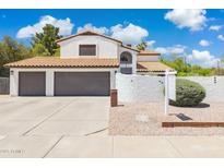 Charming home featuring a gray two-car garage, white stucco exterior, and stylish tile roof at 5556 E Sandra Ter, Scottsdale, AZ 85254