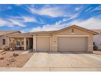 Charming single-story home with a well-manicured lawn, a two-car garage, and a covered front porch at 7241 W Donner Dr, Laveen, AZ 85339