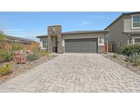 Beautiful home featuring stone accents, a brick driveway, and a two-car garage at 8683 S 165Th Ave, Goodyear, AZ 85338