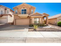 Inviting two-story home with a balcony, desert landscaping, and a two-car garage at 10723 N 118Th Way, Scottsdale, AZ 85259