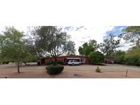 Charming single-story home featuring a red facade, a private driveway, and lush greenery at 12402 N 65Th St, Scottsdale, AZ 85254