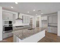 This kitchen features stainless steel appliances, granite countertops, and gray cabinetry at 14789 W Lariat Ln, Surprise, AZ 85387
