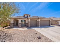 Charming single-story home with a desert landscape, a three-car garage and beautiful architecture at 1520 N Milly Pl, Casa Grande, AZ 85122