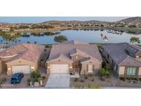 Stunning waterfront home featuring desert landscaping, tile roof, and attached two-car garage at 18135 W Hope Dr, Goodyear, AZ 85338
