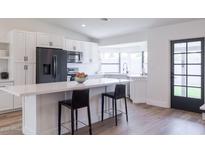 Kitchen featuring an island with bar seating, stainless appliances, and lots of light at 2309 W Naranja Ave, Mesa, AZ 85202