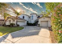 Stunning two-story home featuring lush landscaping, a circular driveway, and multi-car garage at 4497 E Carriage Way, Gilbert, AZ 85297