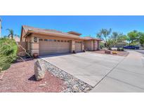 Exterior view of a three-car garage with concrete driveway and desert landscaping at 4560 E Paso Trl, Phoenix, AZ 85050