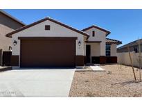 Charming single-story home with a brown-trimmed garage door, neutral stucco, and low-maintenance desert landscaping at 7243 E Cattle Call St, San Tan Valley, AZ 85143