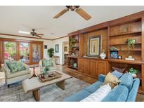 Inviting living room features a custom built-in, Saltillo tile floors, and neutral furnishings at 7526 E Edgemont Ave, Scottsdale, AZ 85251
