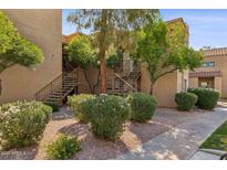 Apartment exterior with well-maintained landscaping and staircases leading to the upper levels at 8787 E Mountain View Rd # 2100, Scottsdale, AZ 85258