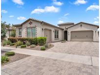 Charming single-story home featuring a brick driveway, manicured landscaping, and a two-car garage at 10006 E Rotation Dr, Mesa, AZ 85212