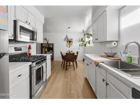 Bright kitchen features white cabinets, stainless steel appliances, and a view of the dining area at 1111 E Turney Ave # 3, Phoenix, AZ 85014