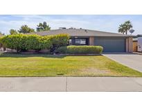 Charming single-story home with a well-maintained lawn, trimmed bushes, and a two-car garage at 12639 N 47Th Ave, Glendale, AZ 85304