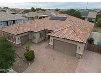 Beautiful single-story home featuring a tile roof, a three car garage, and a brick paver driveway at 14376 W Desert Hills Dr, Surprise, AZ 85379